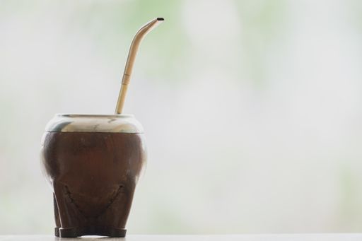 A selective focus shot of a calabash mate cup with straw - yerba mate tea infusion