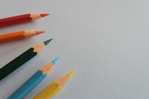 A high angle shot of colorful sharp pencils on a white surface