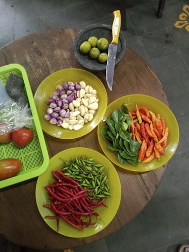 A vertical high angle shot of plates of fresh vegetables on a wooden table
