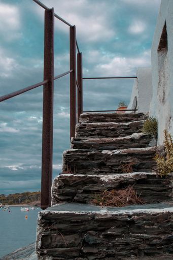 A vertical shot of stairs leading to a roof near the beach during a cloudy day