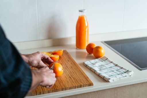 A closeup shot of male hands cutting oranges to squeeze