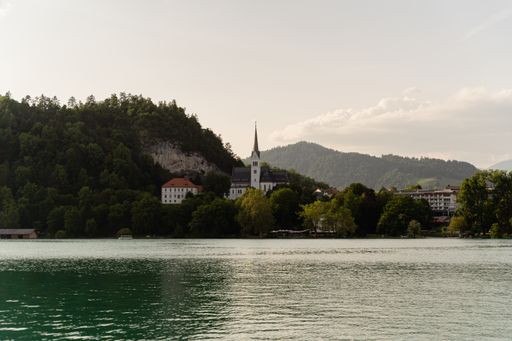 A mesmerizing shot of a castle in Lake Bled, Slovenia surrounded by mountains and forest