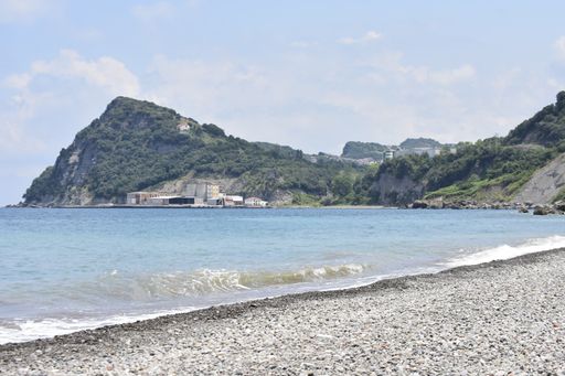 A fantastic shot of a rocky beach and a wavy sea on the hill background