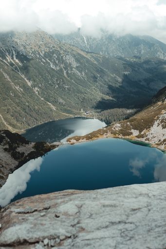 A beautiful view of a lake surrounded by greenery and mountains