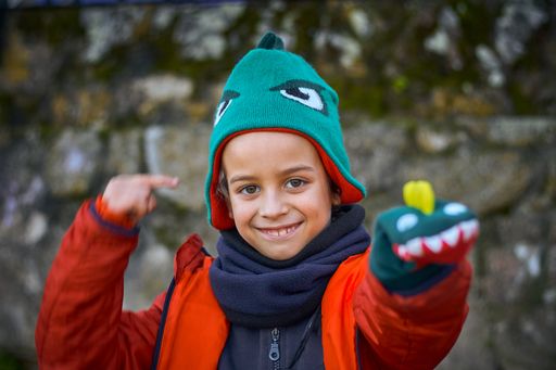 A shallow focus shot of a smiling boy playing outdoors in the park