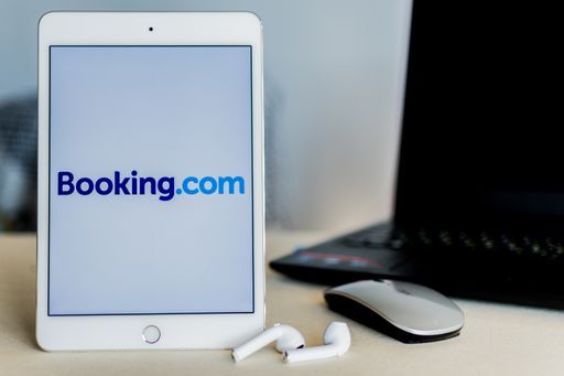 Beer Sheva, Israel. December 20, 2020: Booking logo on tablet screen, next laptop on desk. Logo photo on tablet screen, no editing, no photomontage.