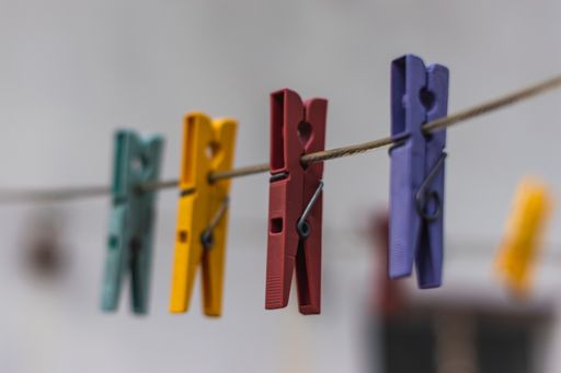 A closeup shot of colorful clothespins hanging from a cable