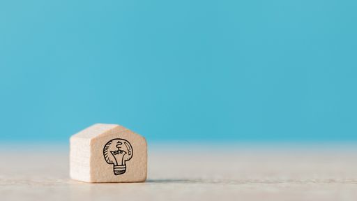A wooden cube with the icon of idea on a blue blurred background - concept of creativeness, new ideas
