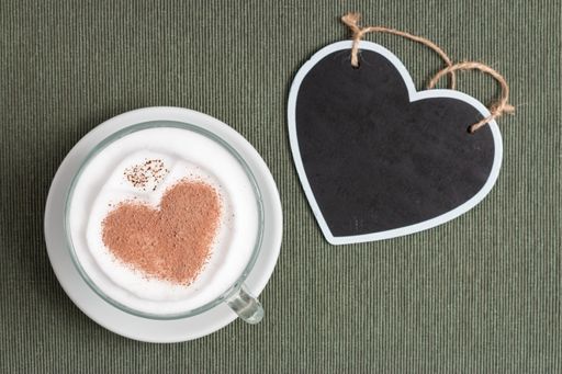 A top view of a heart decoration and a heart-shaped latte on a table