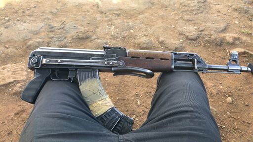 An assault rifle on male knees