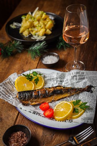 A vertical shot of fried fish and a glass of wine