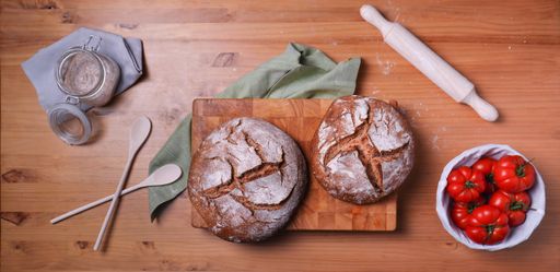 A top view of freshly baked loaves of sourdough bread on a wooden board
