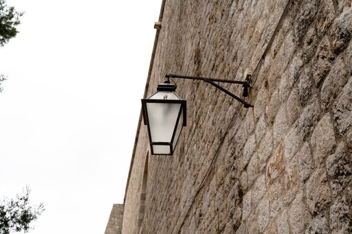 A low angle shot of a street lamp on the stone wall in Dubrovnik, Croatia