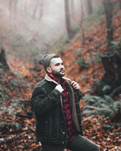A young male hiker on a cold autumn day exploring the forest
