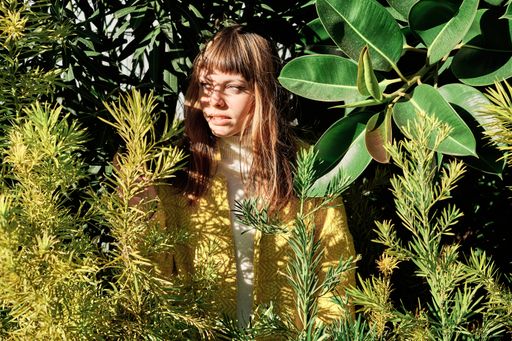 A portrait of a caucasian female posing among the trees on a sunny day