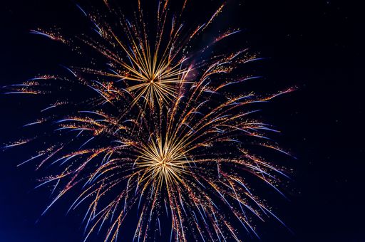 A low angle shot of colorful fireworks with long exposure at night
