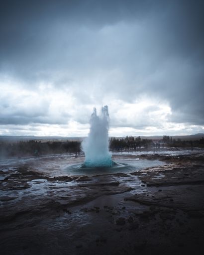 A vertical shot of the Great Geysir exploding in Iceland