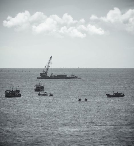 A grayscale shot of construction work on an island in the sea