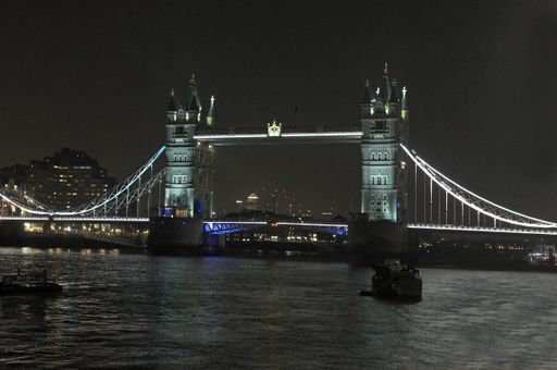 The iconic Tower Bridge, London, United Kingdom, at night time, illuminated and standing out from the night sky and River Thames, below. Copy space.