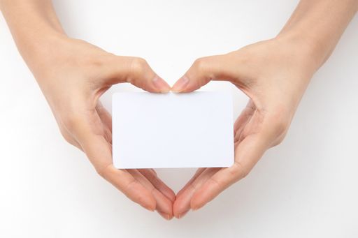 A top view of hands forming a heart and holding a blank paper with space for text