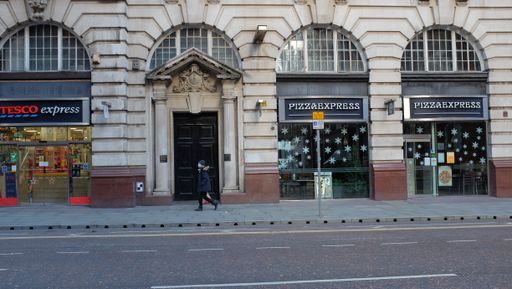 Person walking while wearing face mask in Manchester city centre.