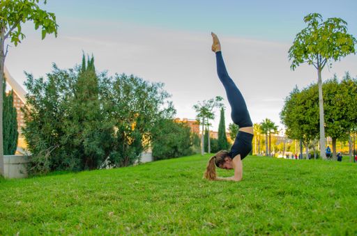 A young Caucasian female doing yoga in a park - healthy lifestyle concept