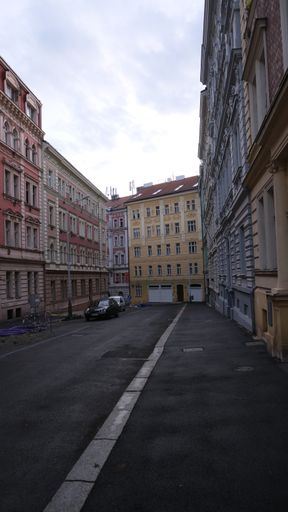 A vertical shot of the colorful buildings surrounding a narrow s