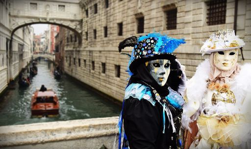 Two people wearing costumes during the Carnival of Venice, next to the Bridge of Sighs (Ponte dei Sospiri) dressed in opposite colours black and white