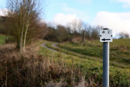 A selective focus shot of a road sign showing the way for hikers