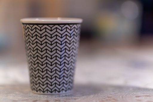 A selective focus shot of a white cup with black patterns