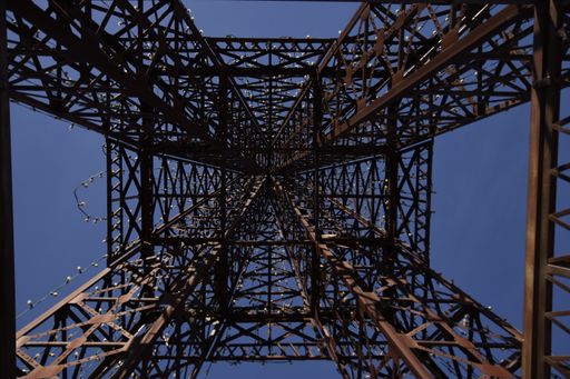 A low angle shot of a metal tower on a blue sky background