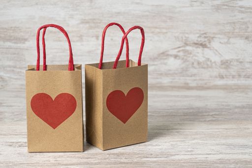 A closeup of gift paper bags  on the table, shopping for St. Valentine's day, background with copy space
