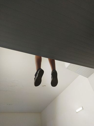A vertical shot of a young boy dangling his legs