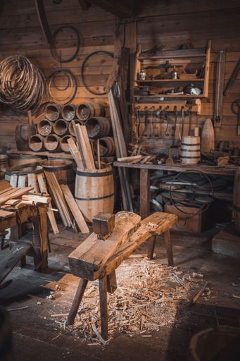 A vertical shot of an old rustic wood workshop with antique tools