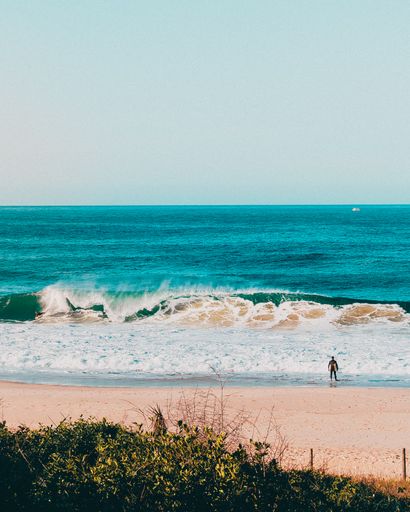 A person watching ocean waves splashing to the shore in Rio de Janeiro