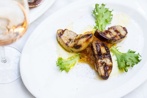 A closeup shot of appetizing foie gras with apricot sauce served on a white plate