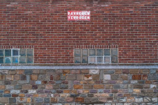 The exterior of an old abandoned building made of red bricks
