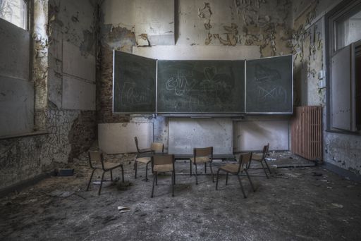 A ruined classroom with dirty aged walls of an abandoned school