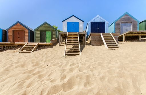 A line of beach huts on a sandy beach
