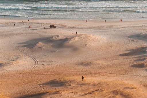 An aerial shot of a sandy beach with people resting