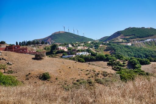 A beautiful view of a small village at the foot of mountains under a blue cloudless sky