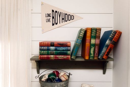 An array of vintage books, a storage chest of baseball mementos on a rustic shelf