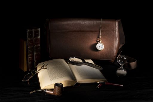 An old book with a vintage watch pipe and glasses