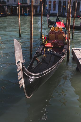 A vertical shot of a boat near the dock in Venice Italy