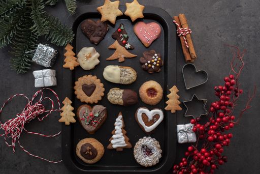 A festive selection of holiday cookies and candy on a black tray