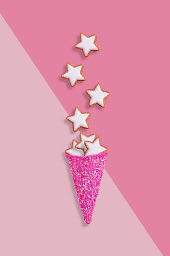 A vertical shot of ice cream illustration with star cookies on a pink background