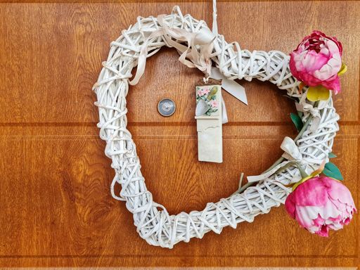 A closeup shot of a white shabby chic wooden decorationin heart shape put on the front door