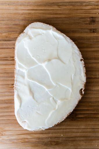 A vertical shot of a breakfast: a slice of bread with a butter on top