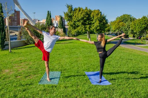 A young athletic couple doing yoga at daytime