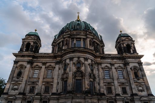 A low angle shot of the Berlin Cathedral on the cloudy sky background, shot from the back si